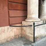 Accanto a Palazzo di Cagno Abbrescia (tra piazza Massari e corso Vittorio Emanuele), Appoggiata allo stilobate sinistro in pietra che regge le due colonne che abbelliscono il portone di legno, si trova una recinzione in ferro appuntita e semi circolare